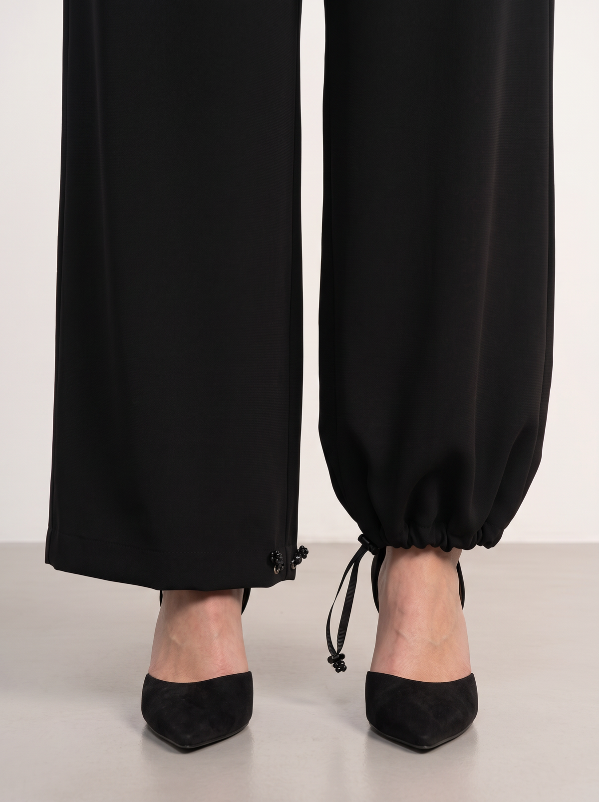 Sadri Couture Roya Pants, tailored crepe-back satin trousers, close-up of fabric and hardware detail.